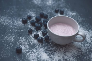 Karanlık bir arka plan üzerinde yaban mersini ile yoğurt