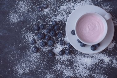 Karanlık bir arka plan üzerinde yaban mersini ile yoğurt