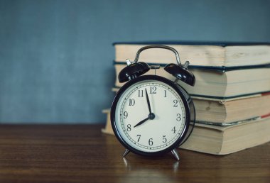 Kitap ve bir çalar saat bir okul yönetimi arka plan üzerinde yalan