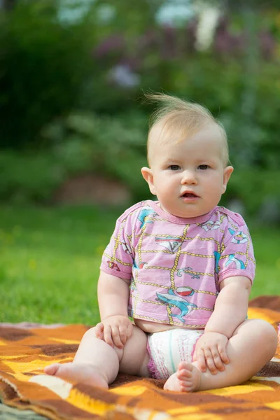 Gordinha, bebê bonito sentado na grama — Fotografia de Stock