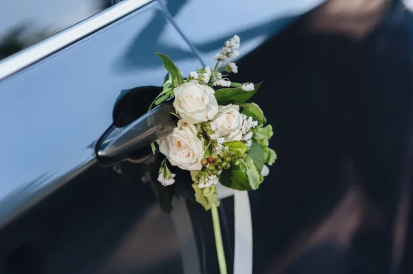 Luxury black wedding car decorated with flowers.