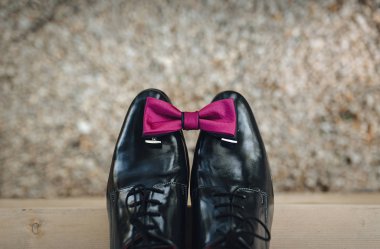 Damat aksesuarları. Bir kravat ve kol düğmeleri rugan ayakkabı üzerinde bir taş zemin üzerine deri ayakkabılar. Üstten Görünüm, bokeh