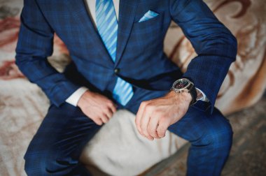 Bir kravat ile elbiseli adam saatine bakıyor. Düğün kavramı