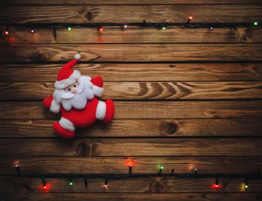 Noel Noel Baba ve garland ahşap tahta üzerinde renkli ışıklar ile arka plan. Kartpostal kavramı.