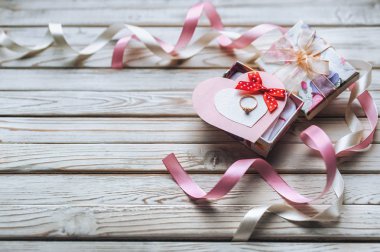 Evlilik teklifi kavramı. Nikah yüzüğü hediye kutusunda ahşap arka plan üzerinde. Sevgililer günü. Festival dekor.