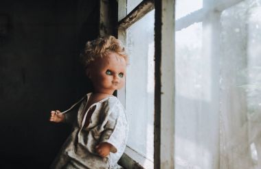 Eski kapısında oturan bebek. Eski ahşap kulübe. Korku, nefret, korku, yalnızlık. Vintage.