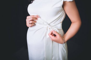 Karnı elleri tutan hamile kadın. Çocuğun doğumu bekliyor.