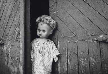Eski kapısında oturan bebek. Eski ahşap kulübe. Korku, nefret, korku, yalnızlık. Vintage.