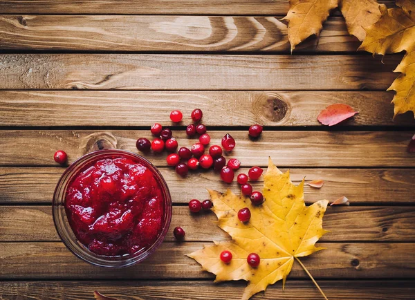 Kızılcık Reçeli, taze meyveler ve ahşap arka plan üzerinde sonbahar yaprakları. Sonbahar vitaminler