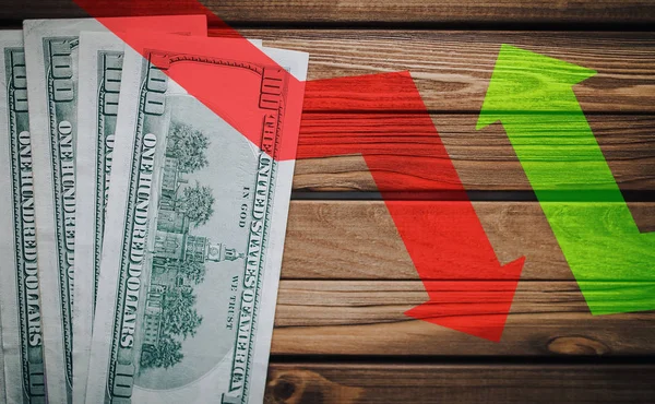 El icono de las flechas rojas y verdes claras sobre un fondo de dinero. El concepto de cambiar el curso del dólar estadounidense en el mercado. Devaluación, colapso, estancamiento de la economía. Fondo de madera . — Foto de Stock