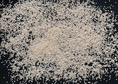 Siyah desenli kağıtta beyaz susam tohumları. Kapat, boşluğu kopyala, üst görünüm.