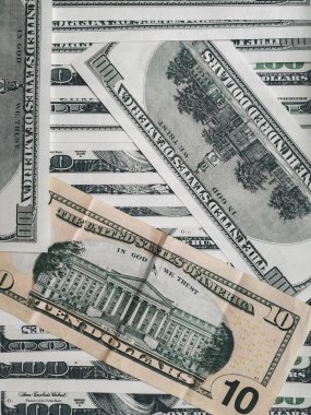 Bir sürü 100 dolarlık banknot ve bir tane 10 dolarlık banknot. Sürdürülebilir dünya para birimi oranları kavramı. Kullanıcı yakın plan fotoğrafı. Finans ve ekonomi.