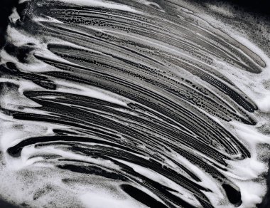 Siyah arka planda beyaz köpük ve sabun. Soyut model. Misafir işçi konsepti. Araba yıkama.