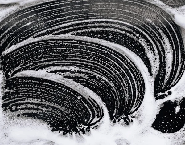 泡と暗い背景の石鹸 抽象的なパターン 洗浄油パンや黒の車の概念 — ストック写真