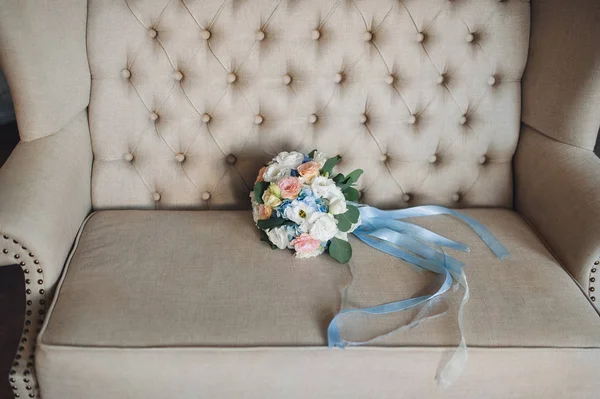 Свадебный букет невесты лежит на диване в винтажном интерьере . — стоковое фото