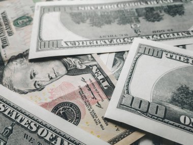 Bir sürü yüz dolarlık banknot ve bir tane de 10 dolarlık banknot. Sürdürülebilir dünya para birimi oranları kavramı. USD yakın çekim fotoğrafı. Finans ve ekonomi.