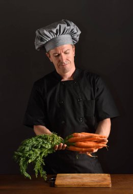 Şef bir havuç siyah bacfground doğrama