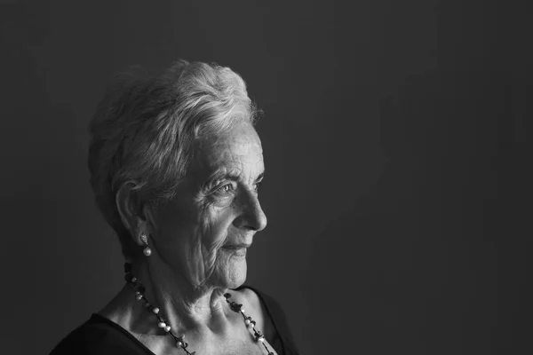 Portret van een senior vrouw op grijze achtergrond — Stockfoto