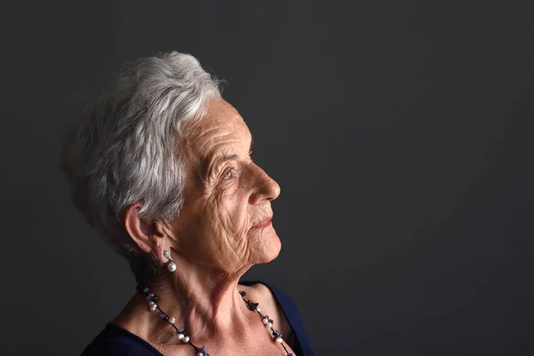 Portrait d'une femme âgée sur fond gris — Photo