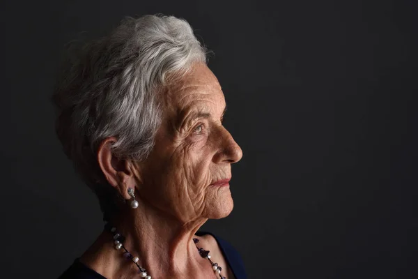 Портрет пожилой женщины на сером фоне — стоковое фото