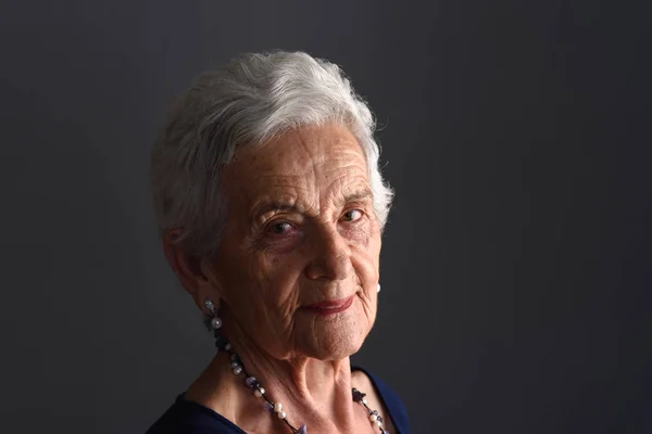 Retrato de una mujer mayor sobre fondo gris —  Fotos de Stock