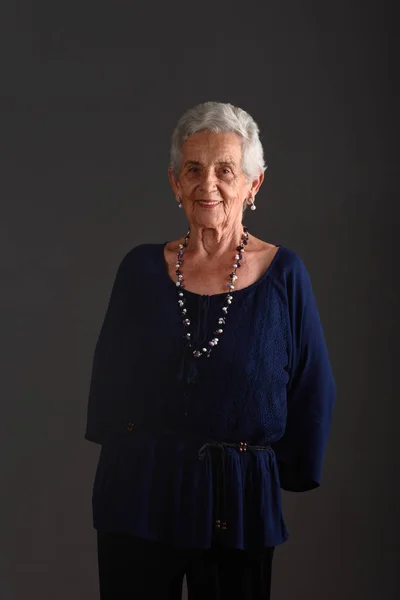 Retrato de uma mulher idosa em fundo cinza — Fotografia de Stock