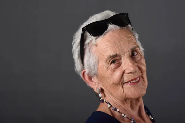 Портрет пожилой женщины в очках на лбу — стоковое фото