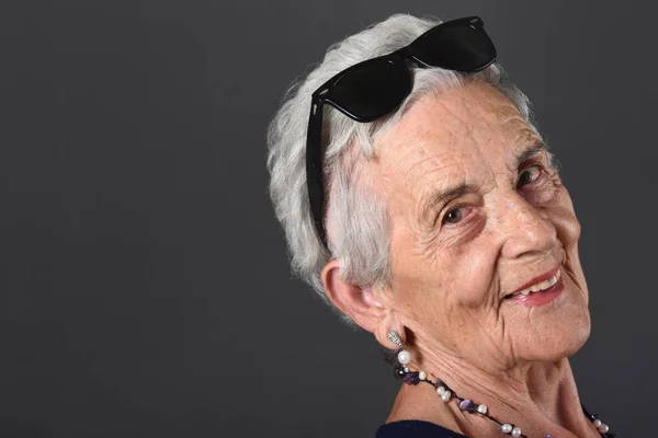 Retrato de uma mulher idosa com óculos na testa — Fotografia de Stock