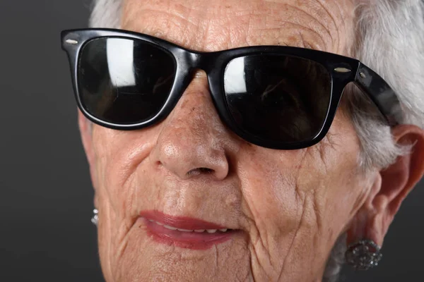 Gözlüklü kadın kıdemli portresi gri arka plan — Stok fotoğraf
