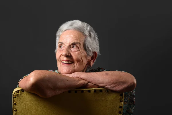 Porträtt av en äldre kvinna med grå bakgrund — Stockfoto
