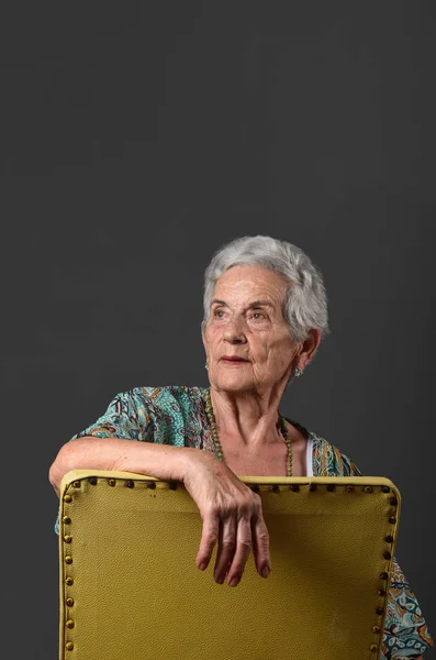 Portret van een senior vrouw met grijze achtergrond — Stockfoto