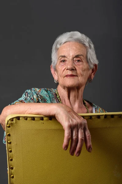 Retrato de uma mulher idosa com fundo cinza — Fotografia de Stock