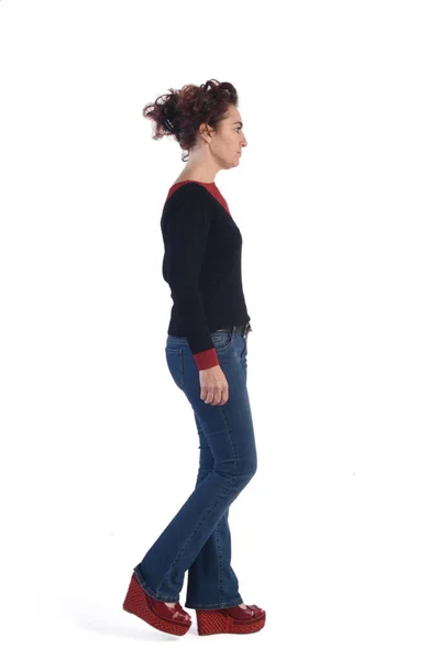 Kvinna med blå jeans gå på vit bakgrund — Stockfoto