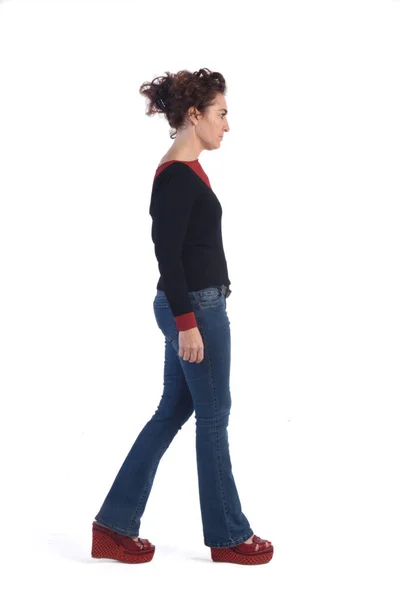 Kvinna med blå jeans gå på vit bakgrund — Stockfoto