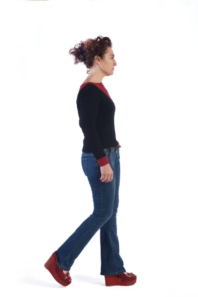 Woman with blue jeans walking on a white background — Stock Photo, Image