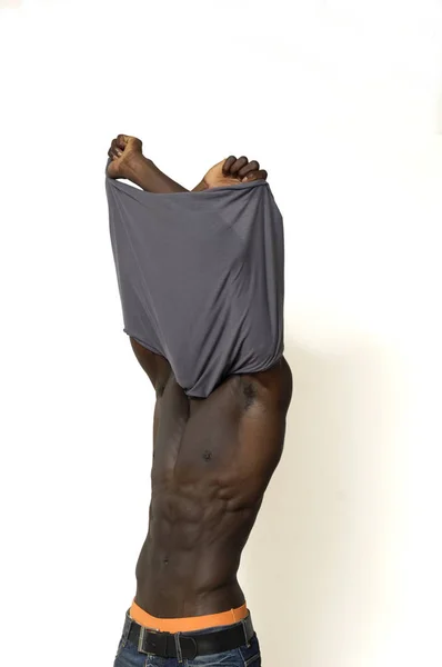 Hombre africano quitándose la camisa — Foto de Stock