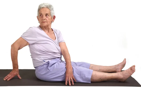 Femme âgée faisant du yoga, isolée — Photo