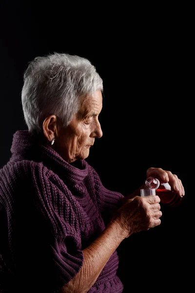 Oude vrouw nemen siroop — Stockfoto