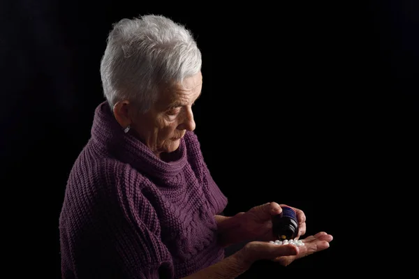 Mujer mayor buscando una píldora — Foto de Stock