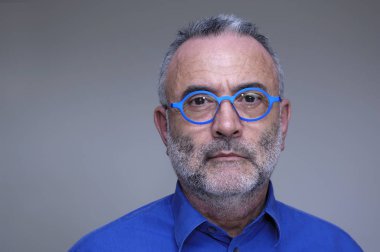 Orta yaşlı adam mavi gömlek ve gözlük