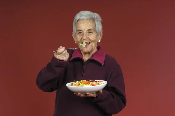 Senior vrouw met salade — Stockfoto