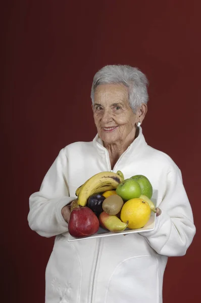 Äldre kvinna med frukt — Stockfoto