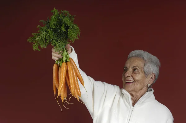 Senior vrouw met wortelen — Stockfoto