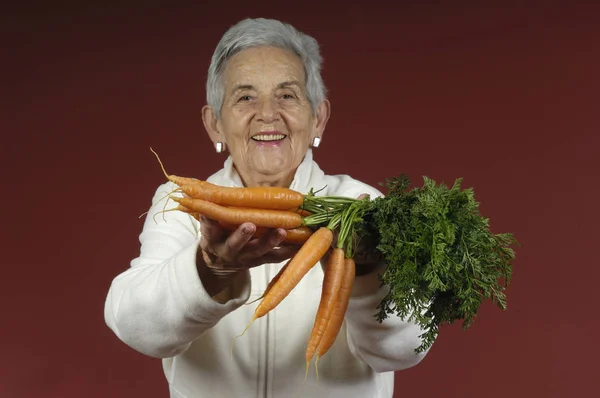 Senior vrouw met wortelen — Stockfoto