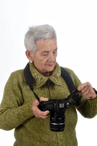 Oudere vrouw op zoek naar een foto op het scherm van de camera — Stockfoto