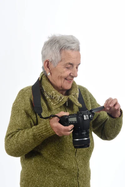 Mujer mayor mirando una imagen en la pantalla de la cámara — Foto de Stock
