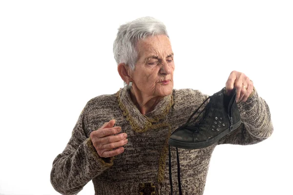 Senior vrouw met stinkende schoenen — Stockfoto