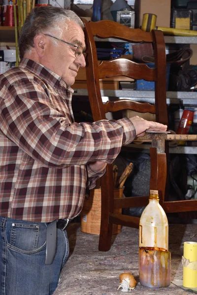 Hombre mayor restaurando una silla —  Fotos de Stock