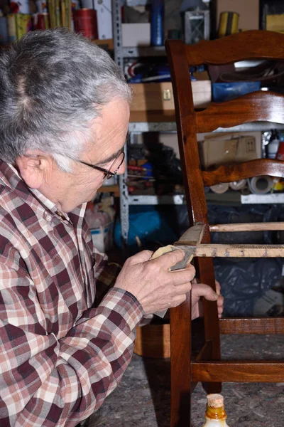Hombre mayor restaurando una silla —  Fotos de Stock