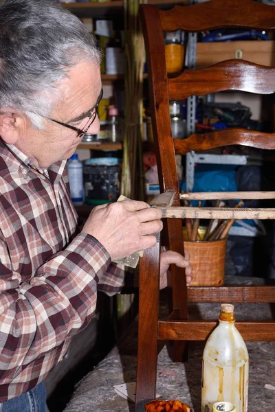 Hombre mayor restaurando una silla —  Fotos de Stock